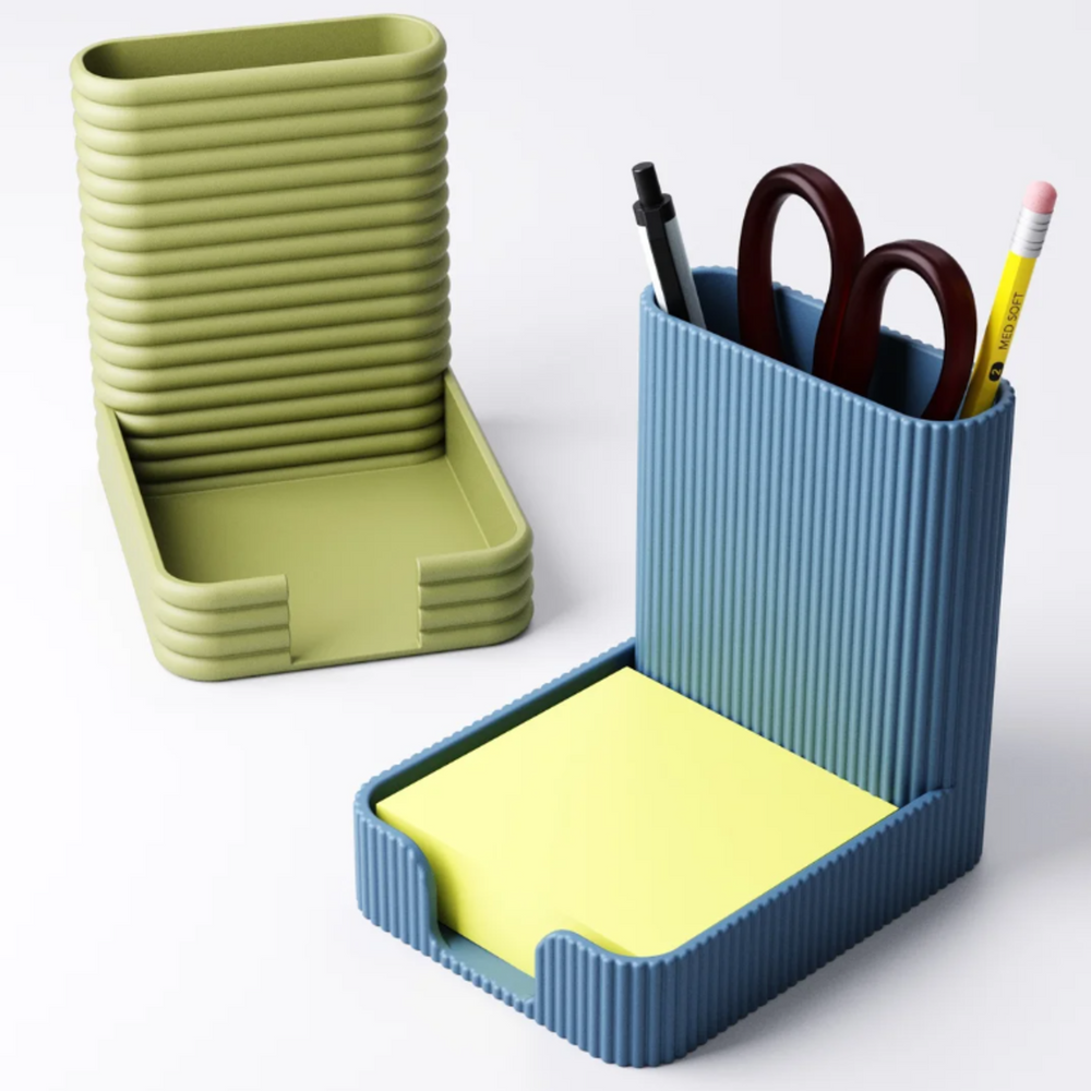 A blue desk organiser with a vertical-ribbed texture, holding pens and a yellow sticky note pad.
An empty olive green desk organiser with a horizontal-fluted texture, shown on a white background.
A side-by-side comparison of the two desk tidy styles, one blue and ribbed, one green and fluted.