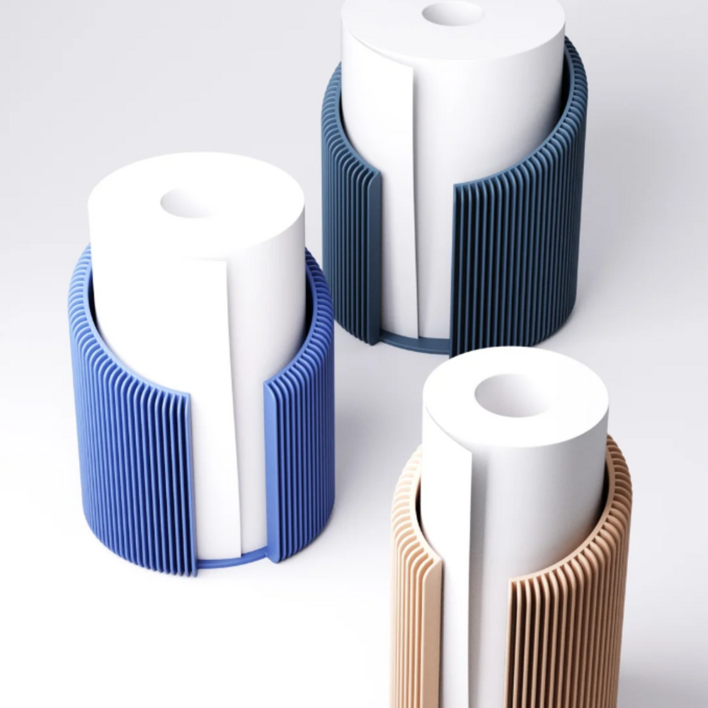 Three modern, 3D printed kitchen roll holders with a ribbed texture in different shades of blue and beige, each holding a white paper towel roll.
A close-up of a blue, ribbed paper towel holder, showing the detailed vertical texture and the opening for the kitchen roll.
A collection of stylish, minimalist kitchen roll holders in various contemporary colours on a clean white background.