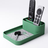 Remote control holder with tray in green, holding three remotes upright