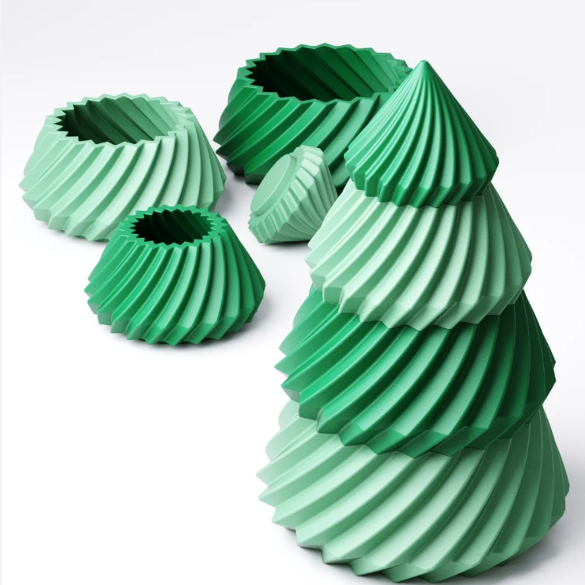 A modern, two-tone green stacking Christmas tree with a swirling texture, shown fully assembled next to its unstacked parts.
The four tiers of a modern green Christmas tree unstacked to show the hidden storage compartments inside each layer.
A stylish 3D printed Christmas tree with four stacking layers in alternating light and dark green.