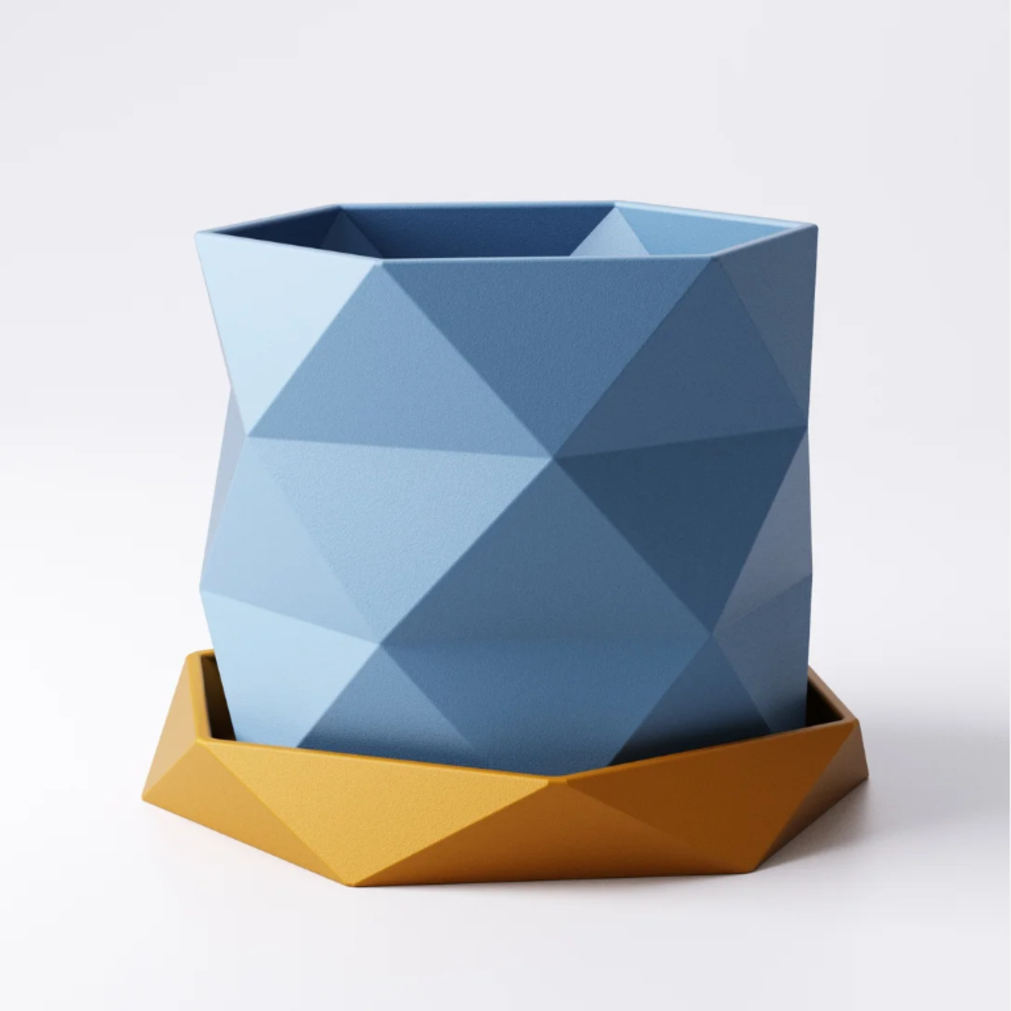 A 3D printed blue Triangle geometric planter with a twisted, faceted design, shown floating above its matching yellow hexagonal drip tray against a white background.