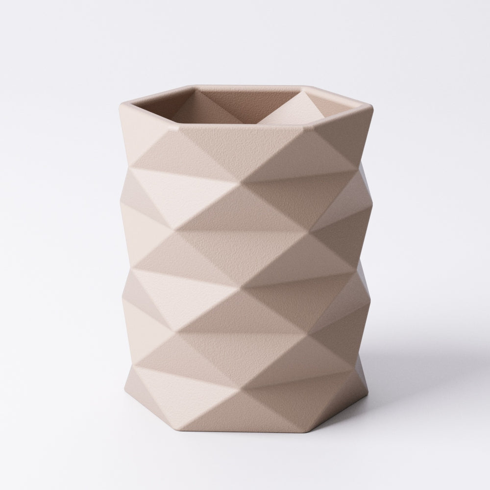 Geometric tealight holder, faceted hexagonal design, shown in a neutral colour with an LED tealight