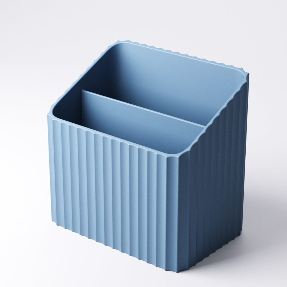 Ribbed remote holder with wide and narrow sections styled on a shelf