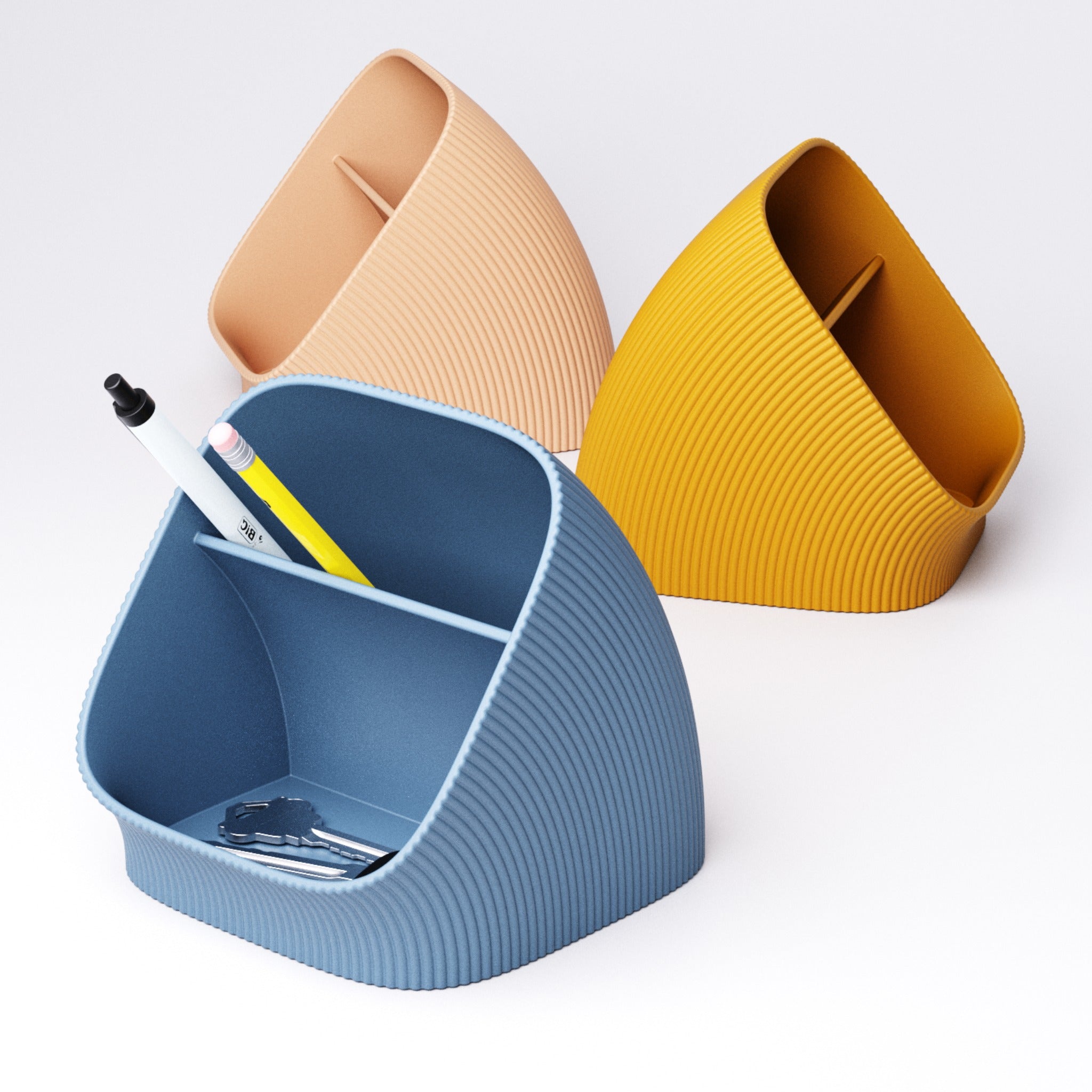Ribbed desk organiser in ivory white, blue and mustard holding pens and pencils upright