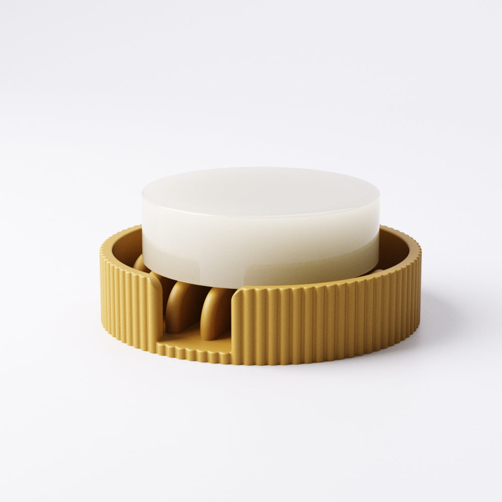 Round soap tray with raised fin bumps holding a bar of soap above drainage gaps